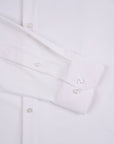 Close-up of a white dress shirt with buttons on a light gray background