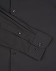 Close-up of a dark gray shirt with button details on a matching fabric background