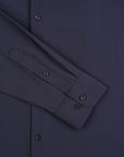 Close-up of a dark blue shirt with button details on a matching fabric background