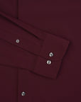 Close-up of a burgundy shirt with button details on a matching fabric background