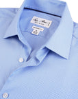 Close-up of a blue checkered dress shirt with a brand label on a white background