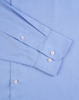 Close-up of a blue checkered shirt with rolled-up sleeves.