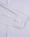 Close-up of a blue checkered dress shirt with rolled-up sleeves.