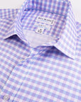 Close-up of a purple and white checkered shirt with 'Bill Blass' label.