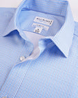 Close-up of a blue checkered shirt with 'Bill Blass' label on a light gray background