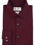 Folded maroon dress shirt with a visible brand label on a white background
