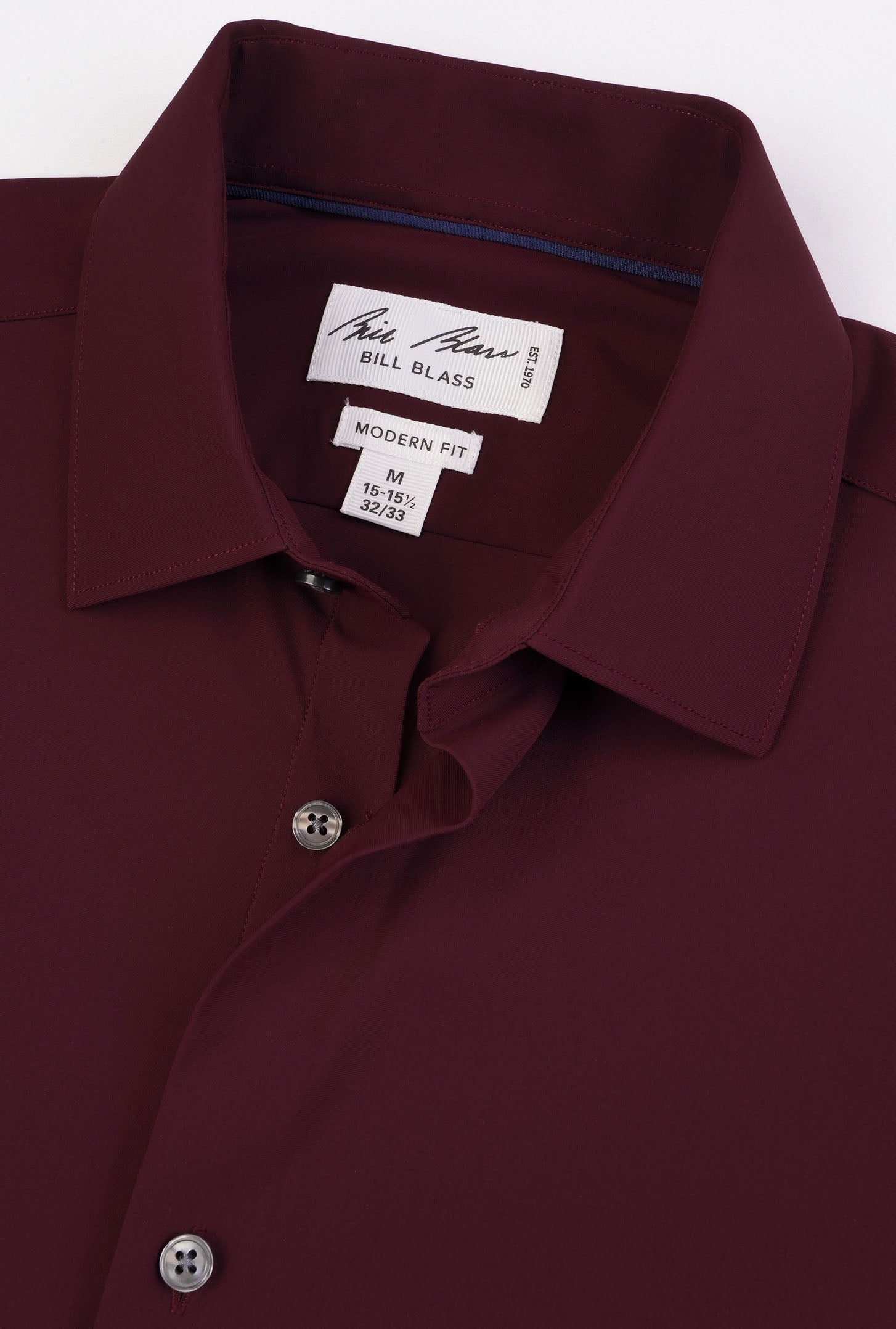 Close-up of a maroon shirt with a brand label on a white background