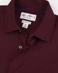Close-up of a maroon shirt with a brand label on a white background