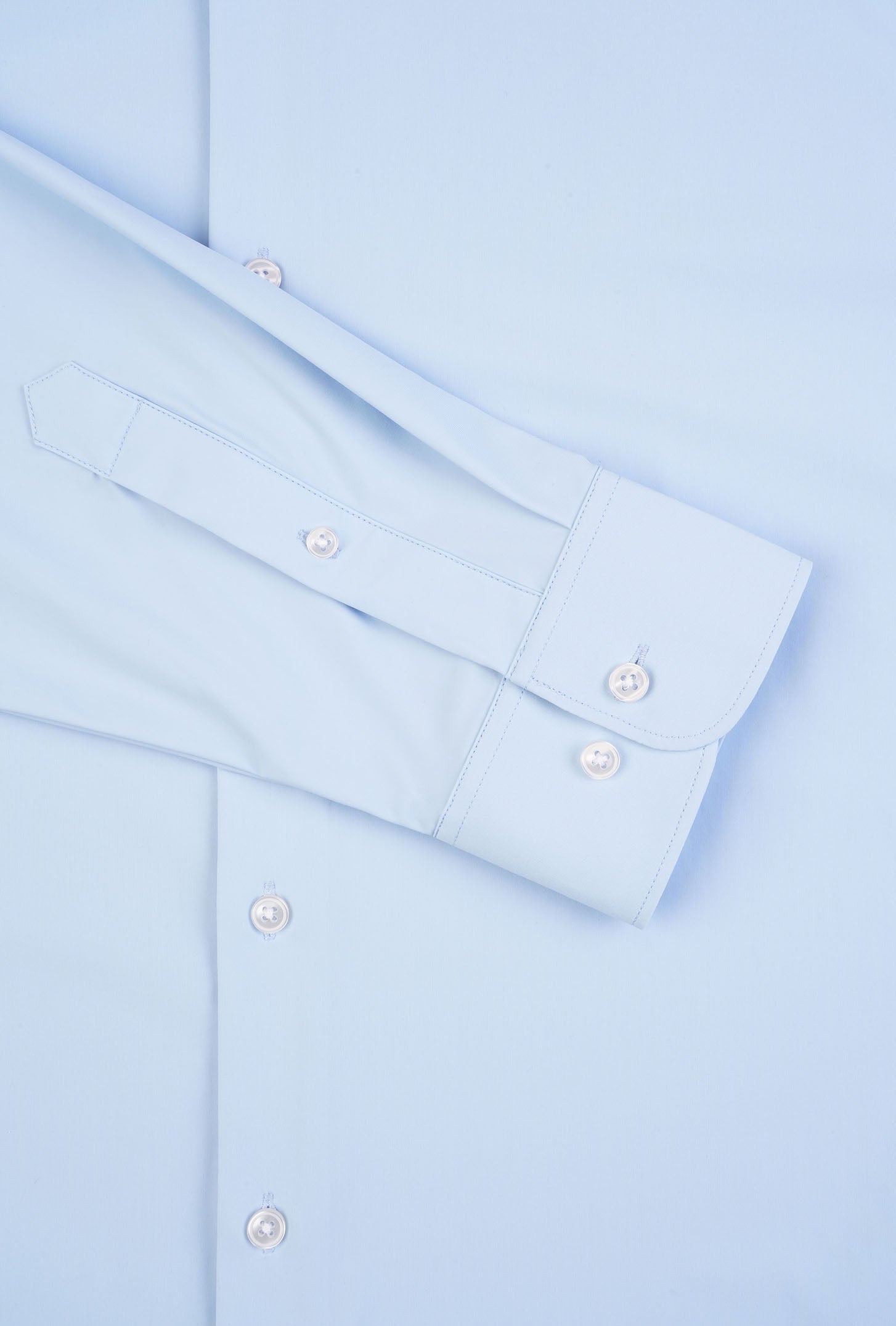 Light blue dress shirt with folded collar and cuffs on a matching background
