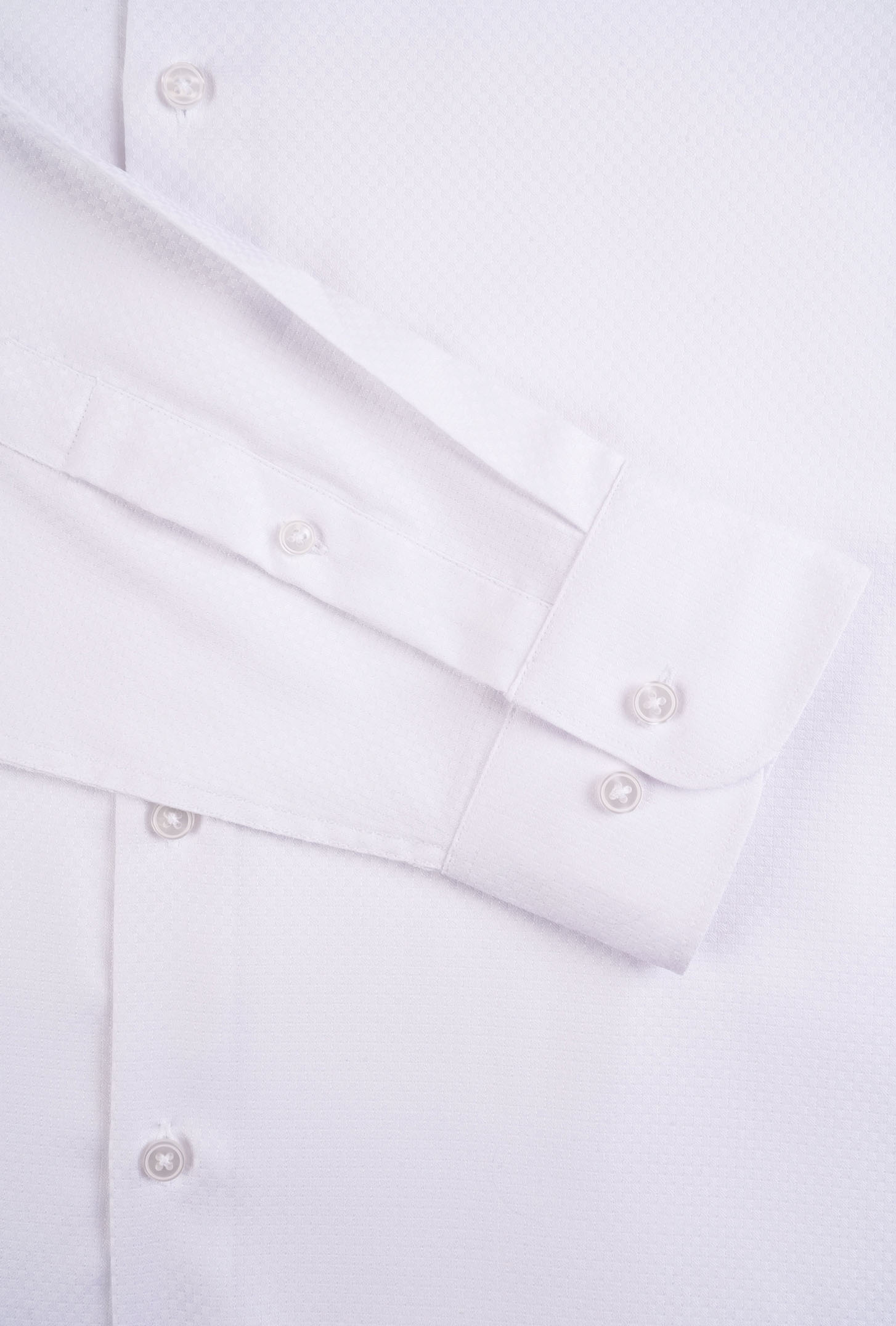 Close-up of a white shirt with buttons on a light gray background