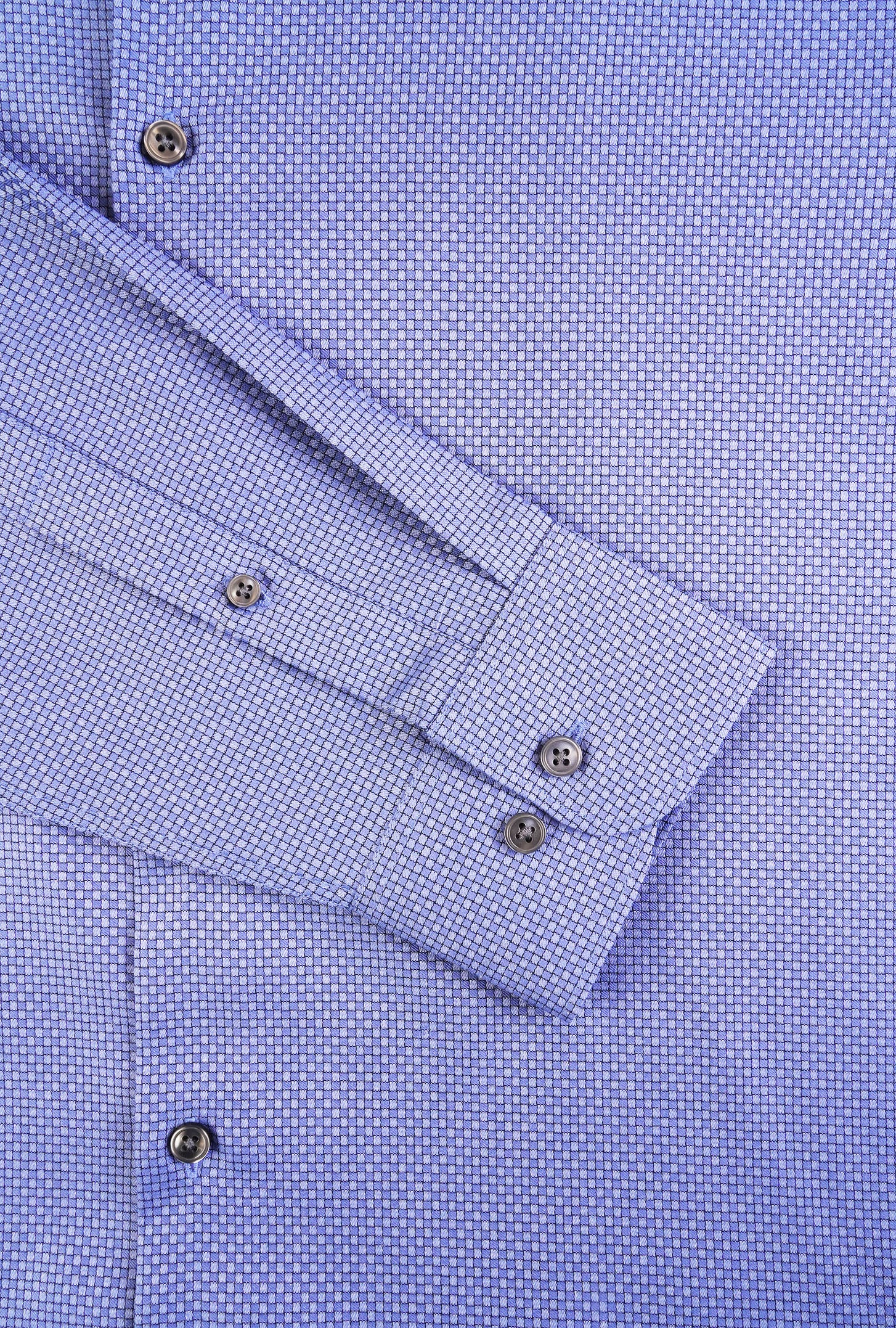 Close-up of a blue checkered shirt with rolled-up sleeves and button details.