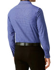 Person wearing a blue checkered shirt and black pants on a light gray background