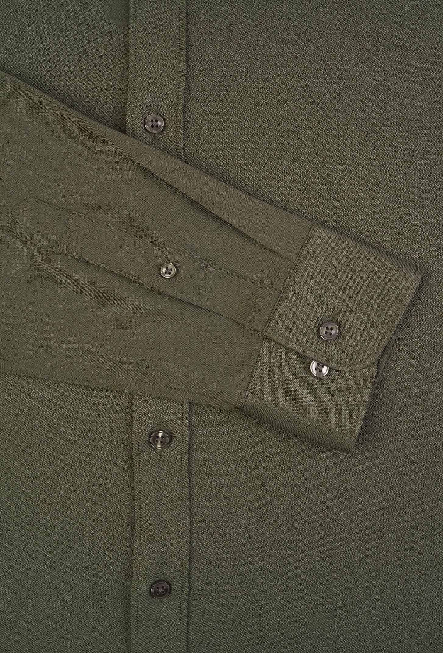 Close-up of a green shirt with button details on a plain background