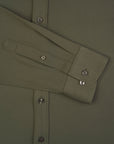 Close-up of a green shirt with button details on a plain background