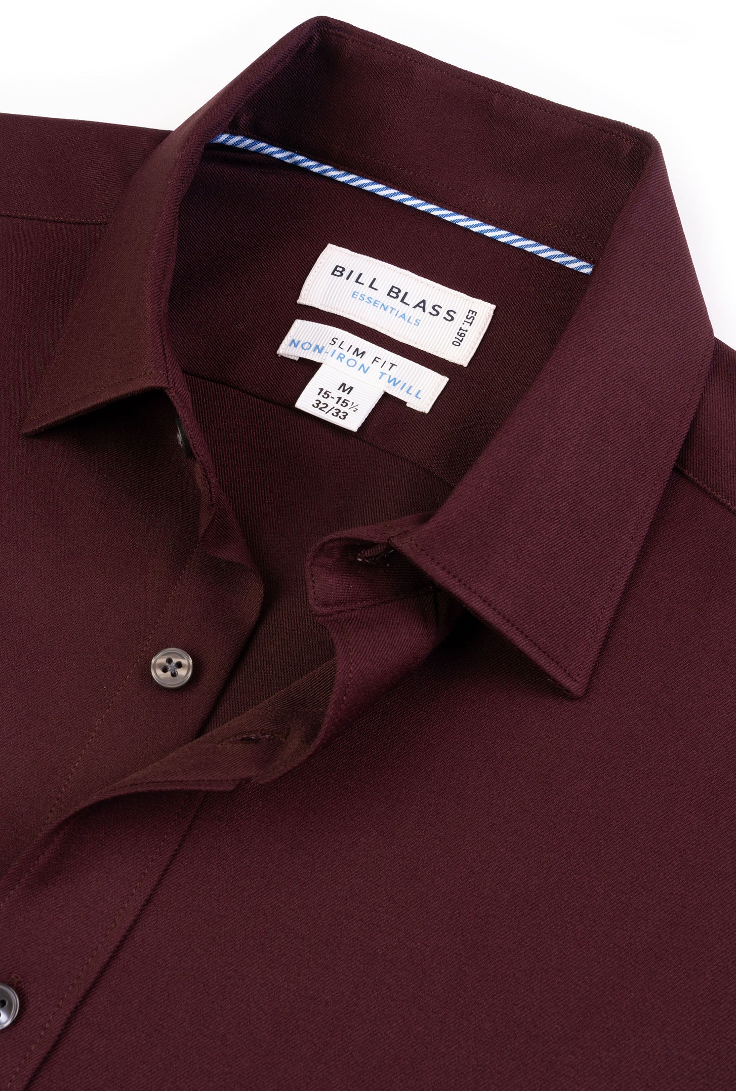 Close-up of a maroon shirt with a Bill Blass label on a white background