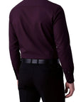 Person wearing a dark purple dress shirt and black pants on a white background