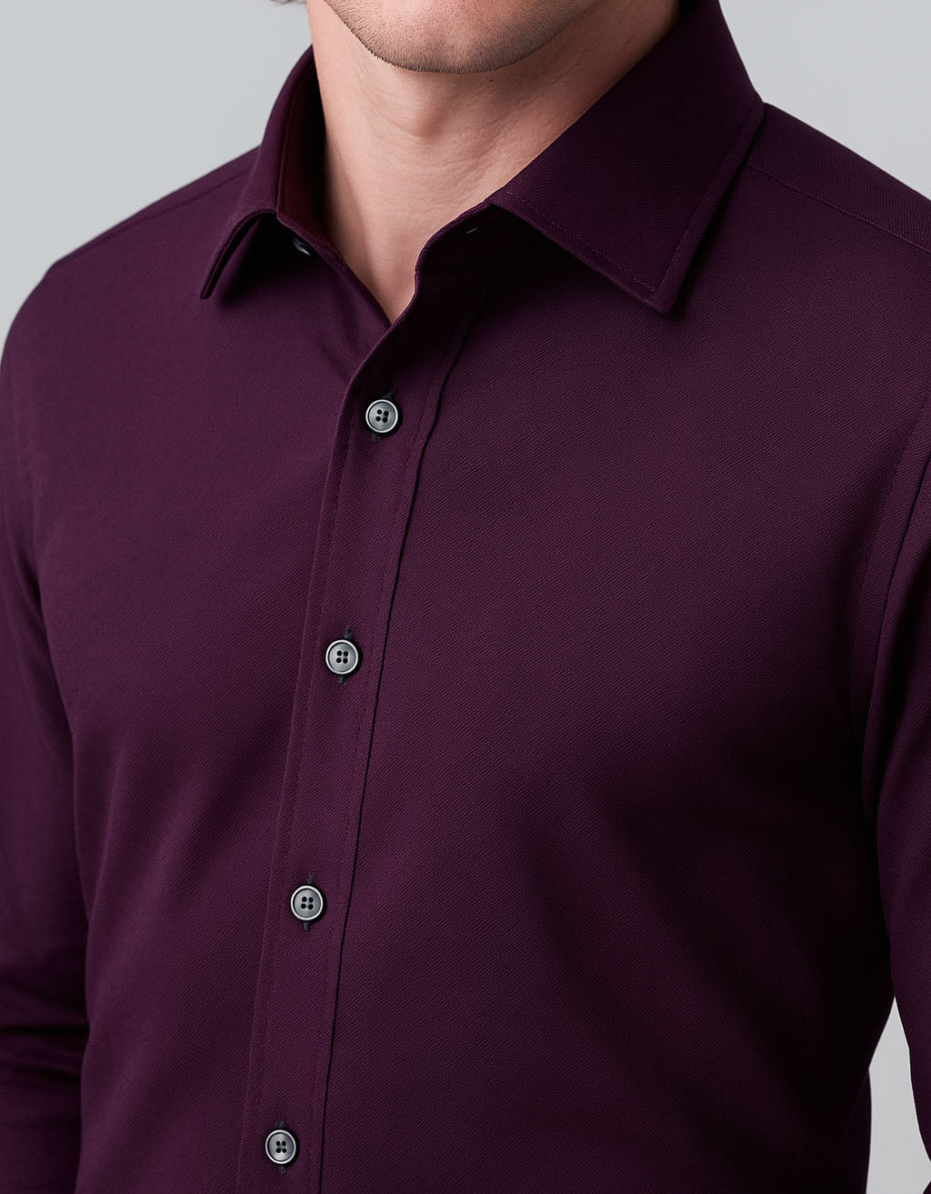 Close-up of a purple button-up shirt on a gray background