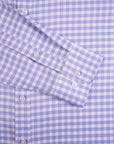 Close-up of a blue and white checkered shirt with rolled-up sleeve.