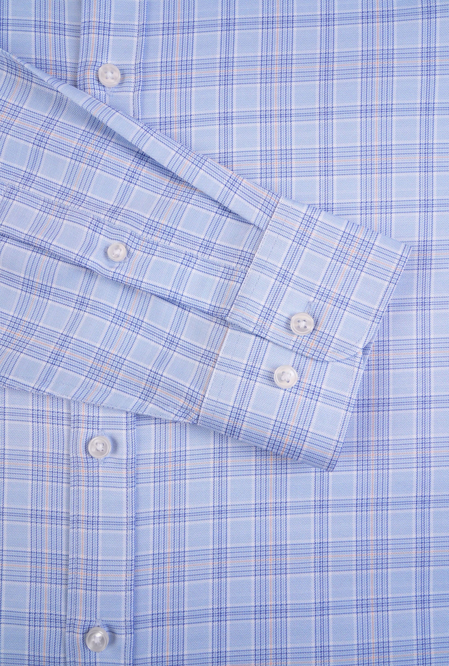 Close-up of a blue checkered shirt with rolled-up sleeves.