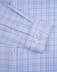 Close-up of a blue checkered shirt with rolled-up sleeves.